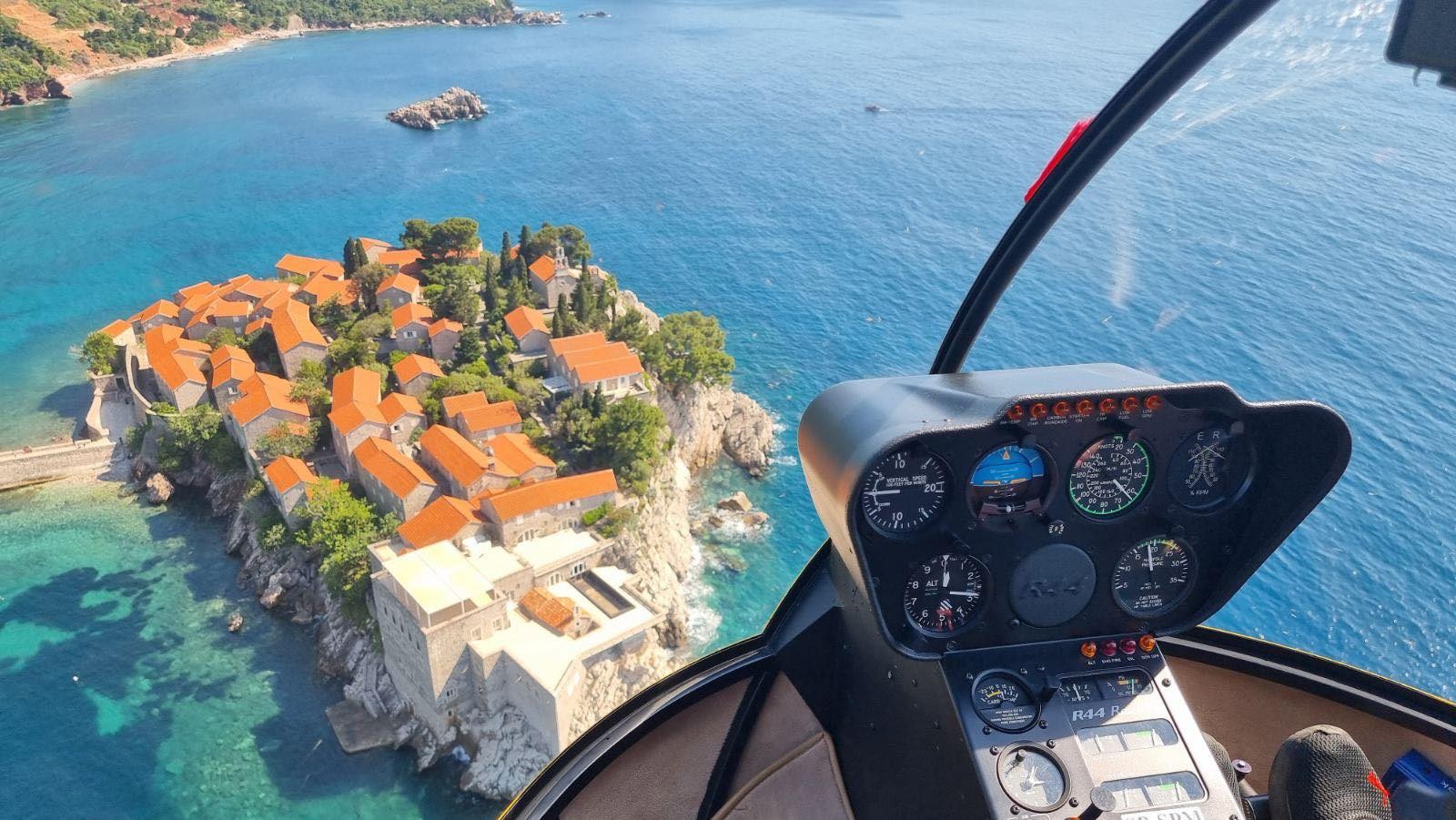 Robinson R44 cockpit above the coast